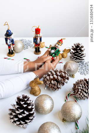 Child hands decorating with nutcrackers and glittery ornaments for Christmas 131680434