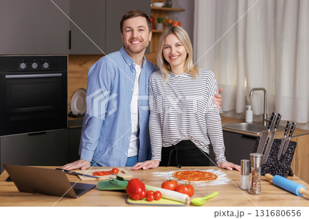 Happy young couple is preparing healthy and tasty food on modern kitchen. Healthy food concept. 131680656