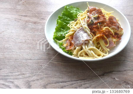 fried spaghetti white cabonara cream sauce topping slice crispy pork bacon and lettuce on plate  131680769