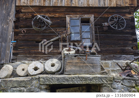 Old wooden house showing antique tools and millstones in Sekowa 131680904
