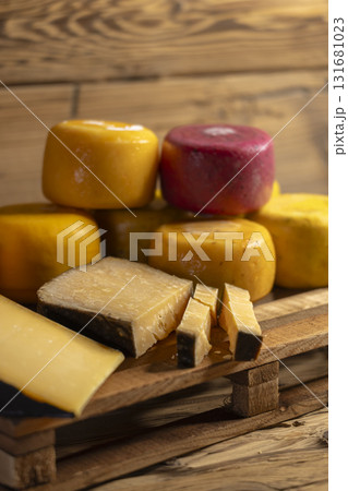 Cheese wheels and wedges on rustic wooden pallet 131681023