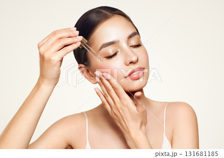 Young beautiful woman applying face serum 131681185