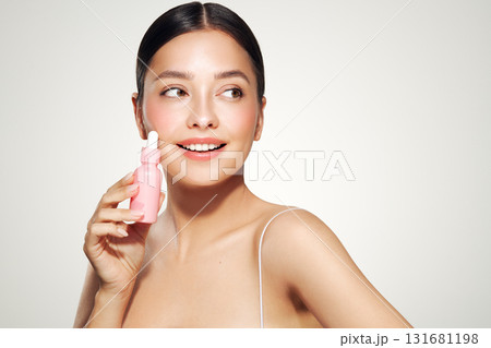 Woman holding a cosmetic jar of oil serum Woman holding a cosmetic jar of oil serum 131681198