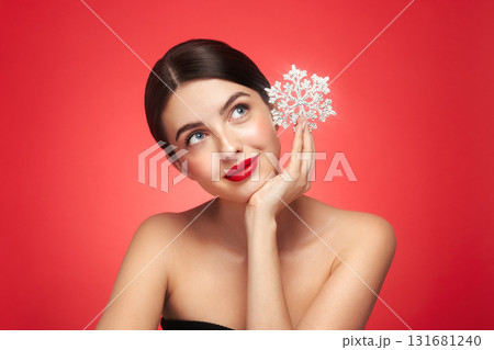 Beautiful young woman with glowing snowflake Beautiful young woman with glowing snowflake 131681240