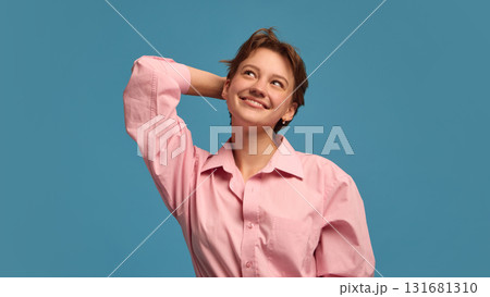 Smiling woman touching head with dreamy thoughtful expression 131681310