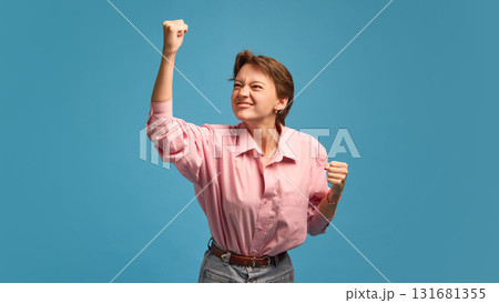 Determined woman raising fist with confident power and motivation Determined woman raising fist with confident power and motivation 131681355