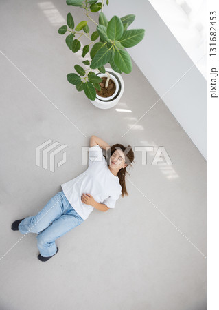 床に仰向けで横たわりリラックスする若い女性 131682453