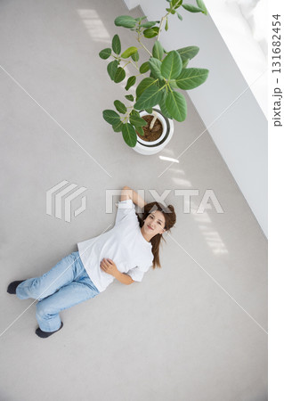 床に仰向けで横たわりリラックスする若い女性 床に仰向けで横たわりリラックスする若い女性 131682454