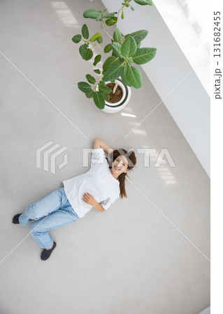 床に仰向けで横たわりリラックスする若い女性 131682455