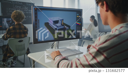 Student in Striped Sweatshirt Works on 3D House Project at Computer Screen Student in Striped Sweatshirt Works on 3D House Project at Computer Screen 131682577