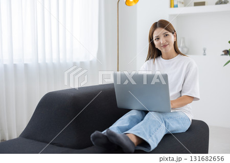 ソファに座ってパソコン作業をする若い女性 ソファに座ってパソコン作業をする若い女性 131682656