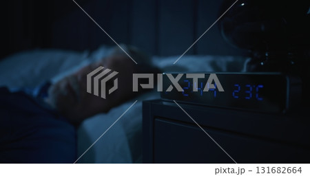 Restless Man in Dark Bedroom, Digital Clock Glowing at Two AM Restless Man in Dark Bedroom, Digital Clock Glowing at Two AM 131682664