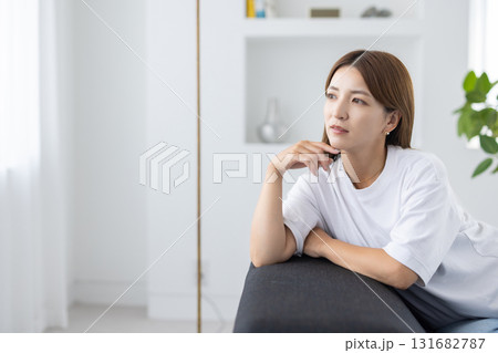 ソファに座って物思いにふける若い女性 ソファに座って物思いにふける若い女性 131682787