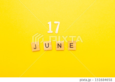 Top view of word 17 June calendar date made by wooden cubes on yellow color background 131684658