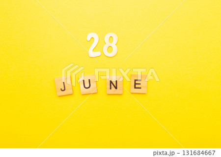 Top view of word 28 June calendar date made by wooden cubes on yellow color background Top view of word 28 June calendar date made by wooden cubes on yellow color background 131684667