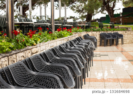 Empty chairs and tables in outdoor restaurant setting waiting for customers Empty chairs and tables in outdoor restaurant setting waiting for customers 131684698