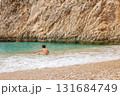 Child sitting at the seashore on summer holiday trip. Travel concept. 131684749