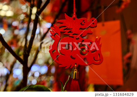 Close-up of the Chinese decoration hanging on the peach blossom plant. Chinese New year celebration. Festive decoration and celebration. For background use. 131684829