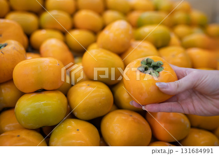 柿を選ぶ女性の手 131684991