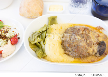 おいしい近距離線ビジネスクラスの機内食の肉料理のハンバーグとサラダ おいしい近距離線ビジネスクラスの機内食の肉料理のハンバーグとサラダ 131685890