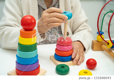 Asian elderly woman playing enhancing skill board game. 131686043