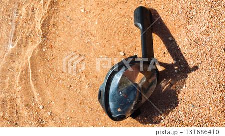 A snorkeling mask floats in the water on the sandy shore of the Red Sea, inviting adventurers to explore the underwater wonders 131686410