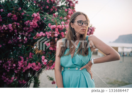 Elegant Woman Posing with Pink Flowers Outdoors Elegant Woman Posing with Pink Flowers Outdoors 131686447