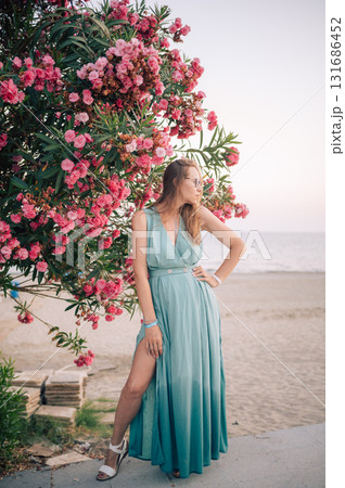 Elegant Woman Posing with Pink Flowers Outdoors Elegant Woman Posing with Pink Flowers Outdoors 131686452
