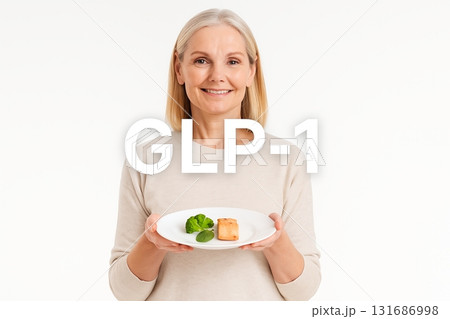 Middle-aged woman holding healthy food on plate with GLP1 concept Middle-aged woman holding healthy food on plate with GLP1 concept 131686998