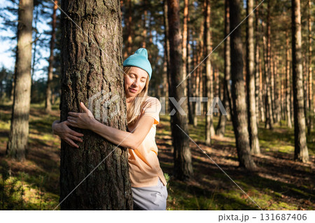 Loving nature purity. Relaxed woman hugging tree trunk in autumn forest at sunset. Stress relief 131687406