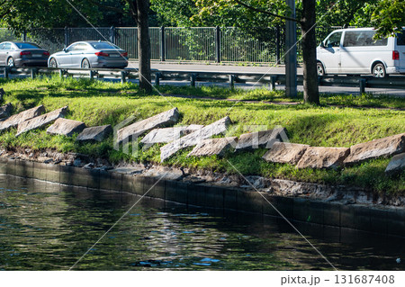 Riverbank infrastructure upkeep in city area. Granite embankment restoration on riverbank with slabs 131687408