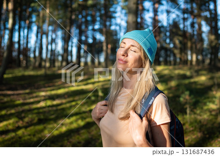 Calm woman stand with closed eyes in autumn forest, enjoying silence, relaxation. Mental recovery 131687436