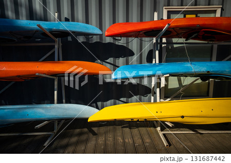 Urban SUP rental station offering water sports on city river and canals. Colorful paddleboards stand 131687442