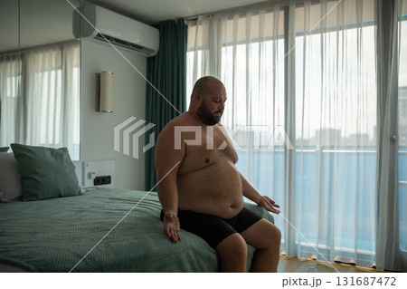 Overweight middle age man tries to normalize breathing. Extreme heat and suffocating stuffiness. 131687472
