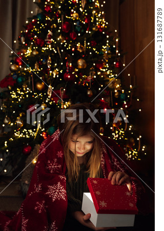 Christmas Surprise Moment with Gift Box. Excited Child Holding Red Christmas Present. holiday excitement, winter warmth, and joyful seasonal celebration Christmas Surprise Moment with Gift Box. Excited Child Holding Red Christmas Present. holiday excitement, winter warmth, and joyful seasonal celebration 131687789
