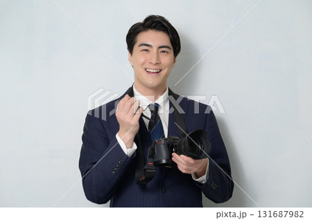 カメラの手入れをするスーツの日本人男性 131687982