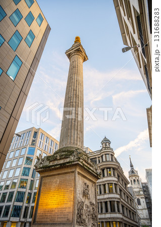 The Monument to the Great Fire of London rises between modern buildings, showcasing its historical significance. The Monument to the Great Fire of London rises between modern buildings, showcasing its historical significance. 131688283