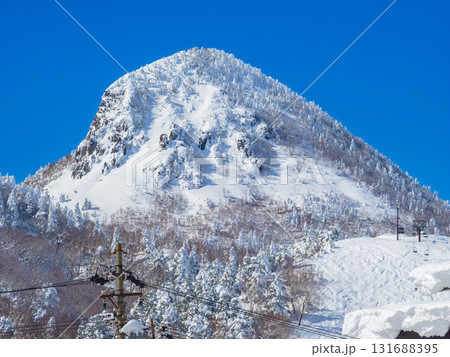 快晴の空の下に広がる樹氷に覆われた笠ヶ岳の頂 (長野県、志賀高原) 131688395