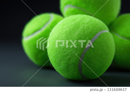 Bright green tennis balls stacked creatively on a dark background for vibrant visual appeal 131689637