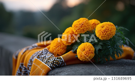 Bright marigold flowers placed on an orange cloth near a scenic outdoor location in the evening 131689695