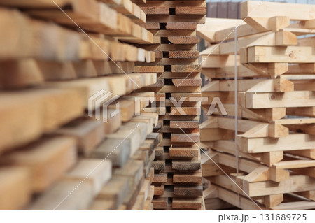 Boards are stacked. Texture of wood is out of focus. Lumber warehouse. Pallets for building materials. Selective focus. Boards are stacked. Texture of wood is out of focus. Lumber warehouse. Pallets for building materials. Selective focus. 131689725