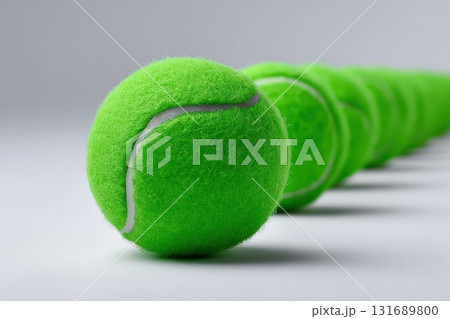 Bright green tennis balls lined up on a white background for sports enthusiasts and players 131689800