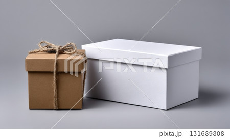 Gift boxes of different sizes on a gray background with a rustic twine bow on the smaller box Gift boxes of different sizes on a gray background with a rustic twine bow on the smaller box 131689808