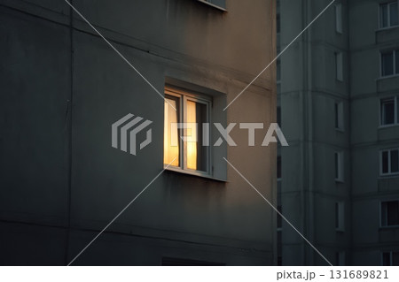 Evening sunlight illuminates a window in an urban building during twilight hours Evening sunlight illuminates a window in an urban building during twilight hours 131689821