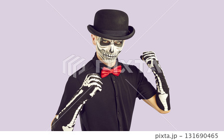 Man in spooky skeleton Halloween costume clenches his fists and is ready to fight Man in spooky skeleton Halloween costume clenches his fists and is ready to fight 131690465