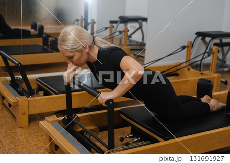 Pilates session focusing on upper body strength and core stability at a fitness studio during morning hours 131691927