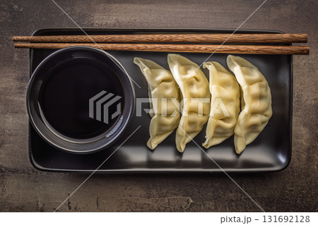 Traditional japanese gyoza dumplings and soy sauce on kitchen table. Top view. 131692128