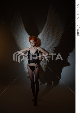 Woman with angel wings in a studio setting showcasing beauty and elegance Woman with angel wings in a studio setting showcasing beauty and elegance 131692209