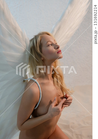Beauty woman with angel wings in studio setting exuding elegance and grace 131692214