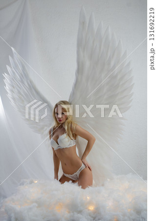Beauty woman in lingerie poses with angel wings in studio setting 131692219